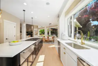 High-end chef’s kitchen w/ refinished cabinetry, expansive island, elegant pendant lighting—designed for both style & function.