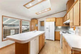 Light-filled kitchen with island and generous cabinet space plus pantry cabinet