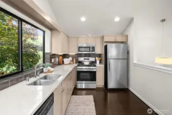 A brand new 5-burner gas stove highlights the sleek and modern kitchen. The window to the left overlooks the shady backyard which provides an almost treehouse feel!