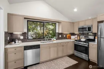 The kitchen features stainless steel appliances, quartz counter tops and glass-tile backsplash.