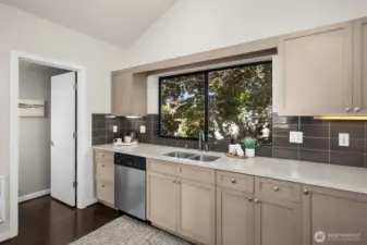 Another view of the kitchen with large window looking into the fully fenced backyard (1/2 bath to the left).