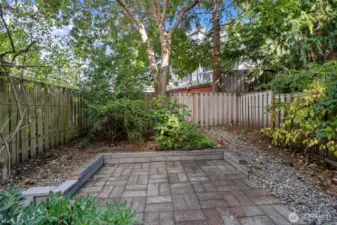 The fully fenced backyard features a nice patio shaded by a large tree. This is a perfect spot for pets, gathering with friends for a BBQ, or to just relax with a good book!