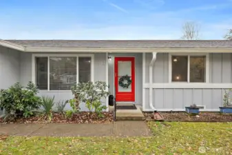 Sidewalk entry into house with 1 step up. Red glass screen door greets you and your guests with warmth. Established landscaping in front garden beds.