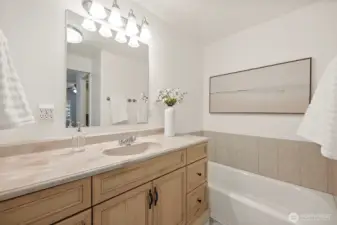 Primary bedroom en-suite bathroom vanity situated next to the soaking tub