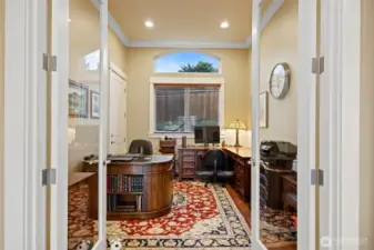 The office is quite large and looks out to the rear landscaped yard. The door opens onto a deck with a patio and gas firepit along side a waterfall with a bridge.