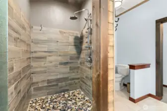 Full tile walk in shower with multiple shower heads.