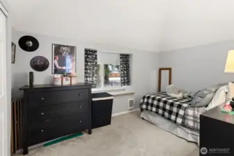 One of the secondary bedrooms boasts vaulted ceilings and a reading nook next to the window!