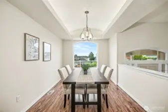 Dining area with natural light and backlit coved ceilings.