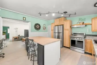 Open kitchen design with generous island seating, flowing into adjacent living space.