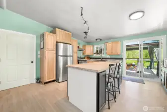 Spacious kitchen with large butcher block island, open layout, and direct access to covered deck.