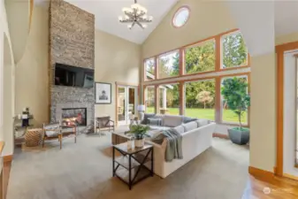 The hub of this home is this massive living room with soaring ceilings and a glass wall of outdoor beauty!
