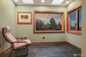Main (South) home upper level master bedroom suite with a sunroom addition featuring heated floors and southwest light, hardwood floors and custom built shelves and closet.