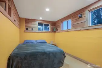 Main (South) home lower level bedroom with laminate bamboo floors and alternating tread staircase to upper level.   Has a separate entry, great income opportunity via vacation rental, housemate, etc.