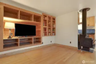 Main (South) home upper level living room with hardwood floors, bump out for entertainment center, woodstove and western exposure.