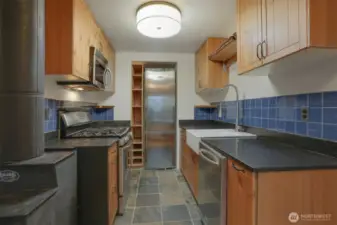 Main (South) home upper level Remodeled kitchen with tile floors, gas range, stainless appliances and bump out for the refrigerator.