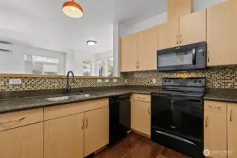 Modern kitchen with granite countertops, stainless steel appliances, and eating ba