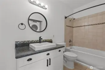 Luxurious bathroom with travertine floors, granite accents, and deep soaking tub