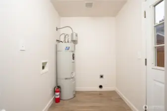 The utility room features a generous space for the washer and dryer as well as extra room for a panty cabinet.