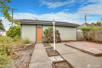 This paved path leads from the back door of the house straight to the workshop room of the garage.