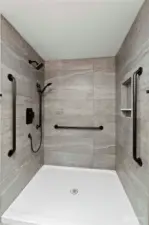 Primary bath also features a floor to ceiling tiled walk-in shower with dual heads.