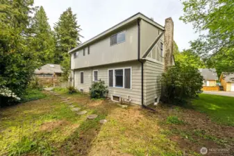 Back view of the two story home, with a cute little partially fenced back yard.