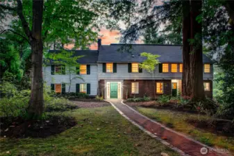 Anchored at the heart of Evergreen Lakeshore Preserve, this stately colonial home radiates timeless charm and quiet grandeur. Framed by towering evergreens and a gently winding brick path, it welcomes you with a sense of permanence and grace. The warm glow from its windows speaks to generations of gatherings, laughter, and life lived close to nature. Though modestly elegant, the home carries with it the legacy of stewardship and the invitation to continue a story that began nearly a century ago.