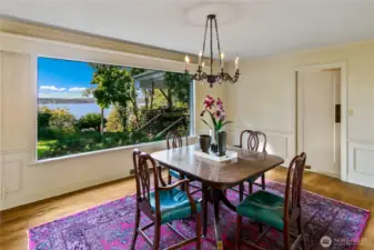 Framed by a picture window that captures sweeping views of the lake and lush gardens beyond, this elegant dining room is infused with light and serenity. Original millwork and a vintage chandelier add warmth and character, while the classic layout invites intimate meals and lively gatherings alike. It’s a space where the beauty of nature meets timeless design, inviting you to linger a little longer at the table.