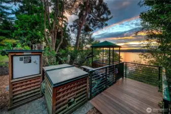 Tucked just above the shoreline, the lakeside grilling area offers a unique blend of comfort and wilderness—perfect for sunset cookouts or morning coffee under the trees. Custom cabinetry, a built-in grill, and ambient lighting enhance the experience, all framed by sweeping views across Lake Washington to the Seattle skyline and Olympic Mountains beyond.