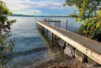 The property's private dock stretches elegantly into the tranquil waters of Lake Washington, offering an unparalleled invitation to swim, launch a kayak, or simply sit and take in the sights and sounds of the water. Tucked into a quiet cove along Evergreen Point, this intimate lakeside perch is a sanctuary for those who cherish both privacy and proximity to nature.