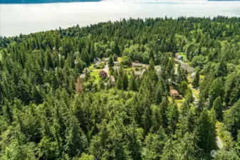 Aerial view of site with neighboring properties and coastline.