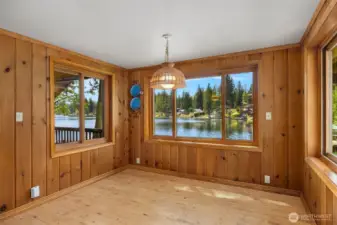 Dining room surrounded by lake views coming in from every angle, providing natural light throughout the space.