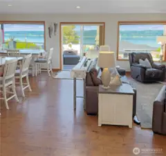 This spacious main-level great room offers the ideal blend of comfort and grandeur, featuring a warm gas fireplace and stunning views that stretch from Port Susan Bay to the snow-capped peaks of Mt. Baker.