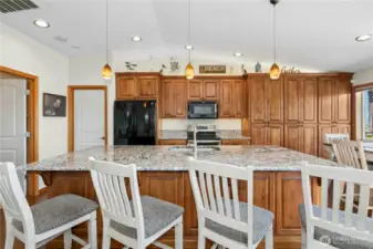Enjoy a chef-inspired kitchen with custom alder cabinetry, generous rollout storage, and a striking 10' x 4' granite island—ideal for culinary adventures and entertaining.