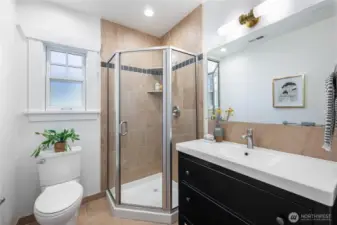 Main level bathroom with modern tile floor and shower surround. New lighting and fresh paint.