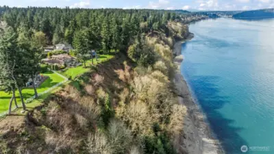 This photo shows that the bluff is well vegetated with mature trees, and its sloped rather than a cliff.