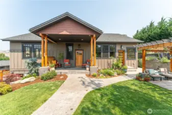 Welcoming craftsman-style entry framed by mature landscaping and timeless architectural details.