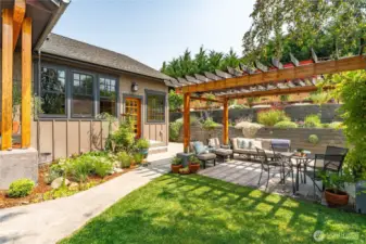 Charming front-yard pergola nestled among vibrant gardens and natural surroundings.