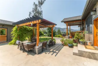 Inviting patio with pergola, detached studio, and direct access to the kitchen—ideal for indoor-outdoor living.