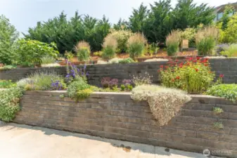Terraced backyard with beautifully maintained garden beds—ideal for outdoor enjoyment and easy upkeep.