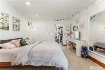 First extra-large lower-level bedroom featuring a walk-in closet and custom built-ins—perfect for guests or multi-generational living.