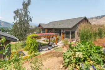Picturesque view of the home from the terraced garden—highlighting its beautiful architecture and lush surroundings.