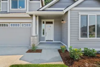 Welcoming entry with stone panels in porch and garage.