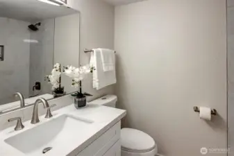 Full bath with tiled tub shower combo.