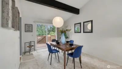 A light-filled dining space with sliding doors leading to the deck
