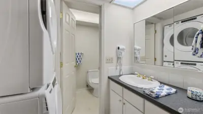 Well-appointed primary bathroom with convenient in-suite laundry