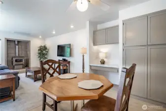 Kitchen dining space with pantry and built-in desk. To the left is a sliding glass door looking to deck and backyard