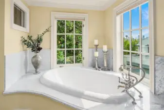 Fabulous soaking tub with handheld shower and Carrara marble surround – classic windows frame a view of the Space Needle.