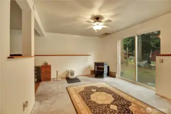 The rec room with a pellet stove and slider to a patio area.