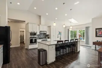 Fantastic kitchen with granite eating bar and counters, white cabinets, and glass tile back splash. Well detailed!