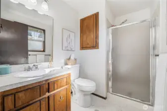 Fresh flooring and plentiful cabinetry create a clean, practical space, ideal for getting ready in the mornings.